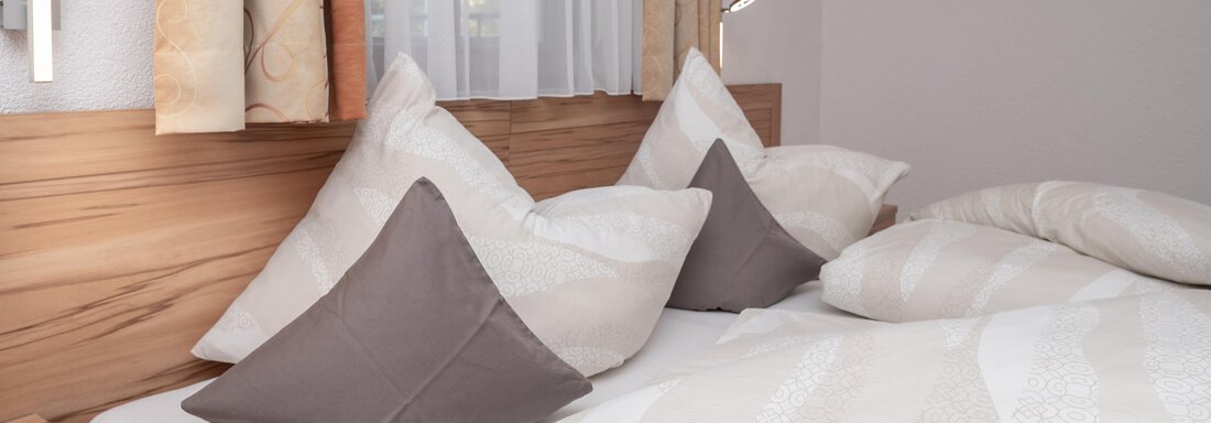 Ein gemütliches Schlafzimmer mit einem Bett, das mit Kissen und einer Decke dekoriert ist. Sanfte Farben und eine entspannte Atmosphäre schaffen eine einladende Umgebung. - Appart Klotz Alpenglück - Längenfeld