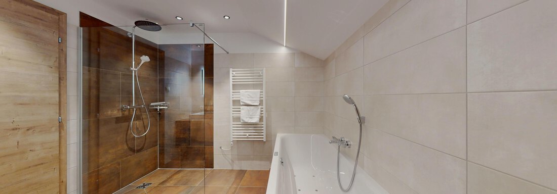 Ein modernes Badezimmer mit einer Dusche und einer Badewanne. Die Wände sind hell, und der Boden ist aus Holz. - Das Berg Loft - Längenfeld
