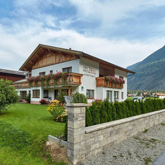 A charming house in the mountains with blooming plants and a well-maintained garden. The surroundings are quiet and offer a picturesque view of the mountains. - Landhaus Zell - Längenfeld