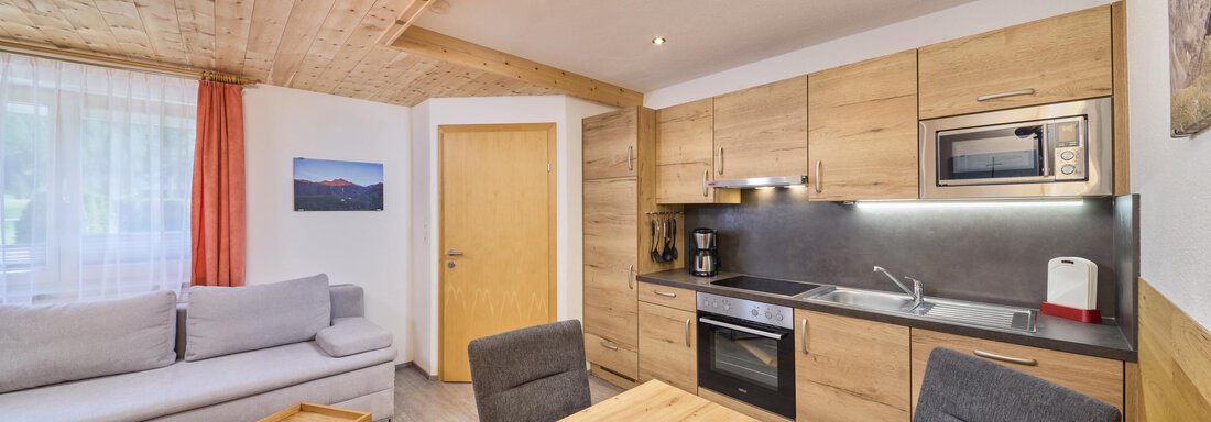 Küche Wohnung Lea A modern kitchen with wooden cabinets and stylish furniture. The space is bright and inviting, ideal for social gatherings. - Appartement Lea - Niederthai