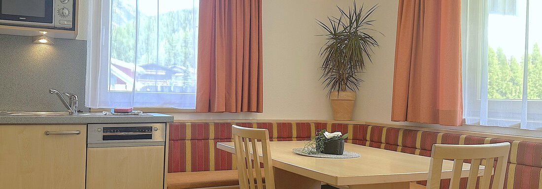 Helle Küche mit Essbereich und Fenstern, die viel Tageslicht hereinlassen. - Appartement Leiter Niki - Niederthai