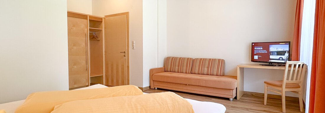 Modernes Zimmer mit Doppelbett, gemütlicher Sitzgelegenheit, Schreibtisch und TV. - Appartement Leiter Niki - Niederthai