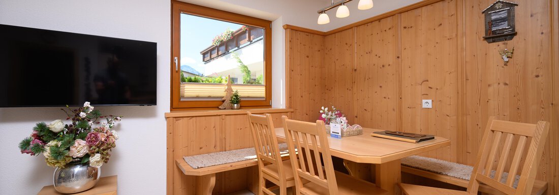 apartment 6 | © A. Kooren (CC C) A cozy dining area with wood paneling. - Delano Appartements - Niederthai