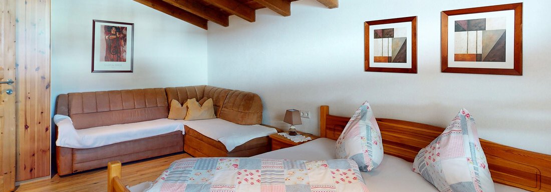 Ein gemütliches Schlafzimmer mit Holzdecke und zwei Betten. Der Raum ist hell und einladend, mit einigen dekorativen Bildern an der Wand. - Gipfelblick Appartements - Niederthai
