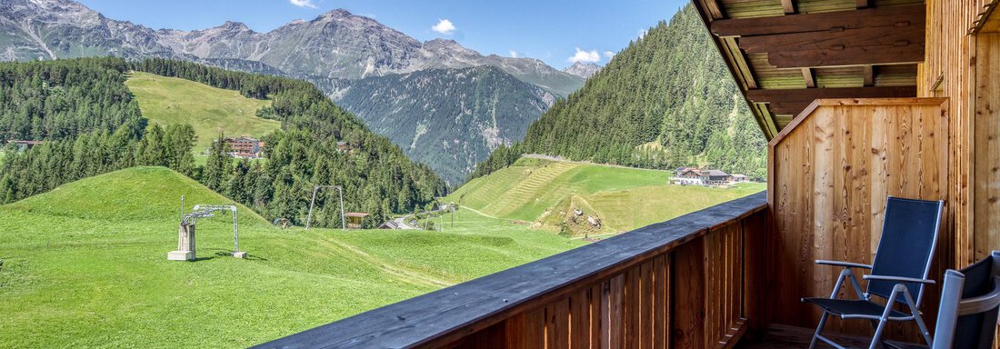 Ein Balkon mit Blick auf grüne Hügel und Berge. Der klare Himmel und die umliegende Natur schaffen eine entspannende Atmosphäre. - Hotel Falknerhof, am Ursprung - Niederthai