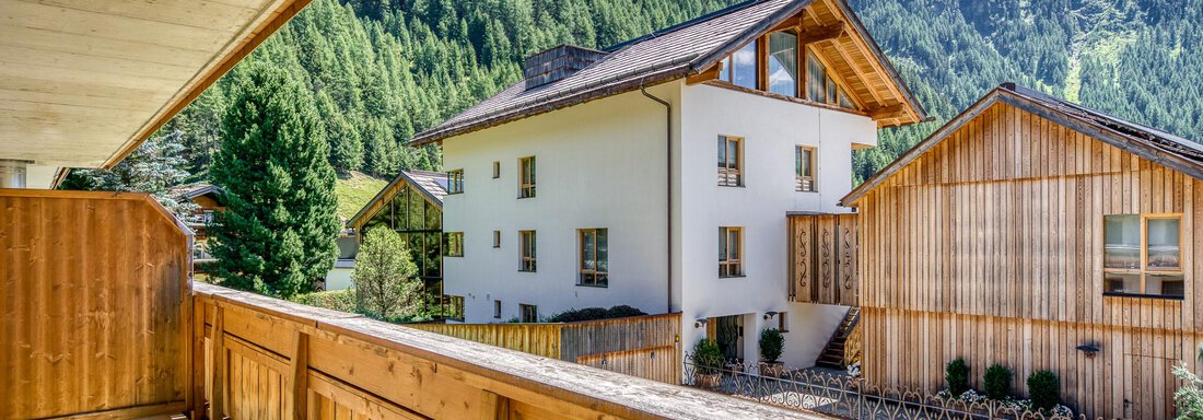 Eine schöne Almhütte mit einem Balkonblick auf die Berge. Die Umgebung ist grün und von tiefem Blau des Himmels umgeben. - Hotel Falknerhof, am Ursprung - Niederthai