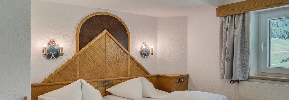Ein gemütliches Schlafzimmer mit zwei Einzelbetten und hellen Wänden. Das Zimmer ist mit Holzdetails und einem Fenster zur Aussicht ausgestattet. - Hotel Falknerhof, am Ursprung - Niederthai