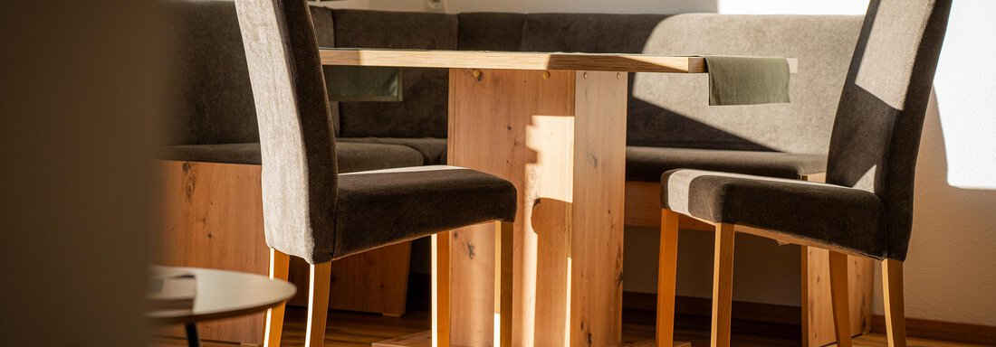Appartement1_Wohnraum0 Ein helles Esszimmer mit einem Holztisch und bequemen Stühlen. Die Sonne scheint durch das Fenster und schafft eine gemütliche Atmosphäre. - Sonnenhof - Niederthai