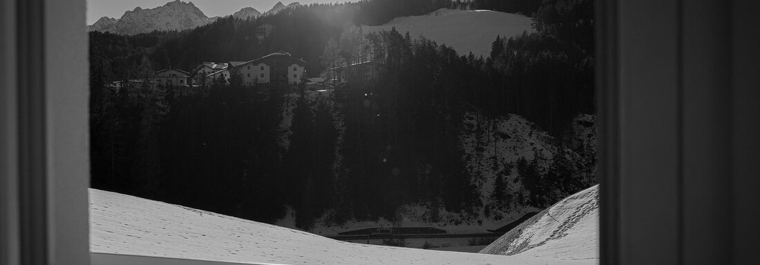 Ein schöner Blick auf verschneite Berge und die sonnige Landschaft. Ein Tisch und Stuhl stehen im Vordergrund, die auf die ruhige Umgebung blicken. - Sonnenhof - Niederthai