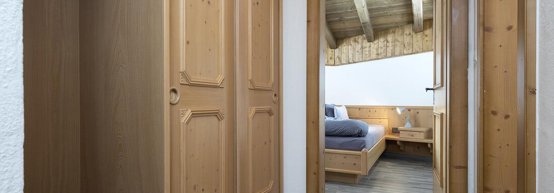 A bright hallway with a wooden cabinet and access to a cozy bedroom. The decor is modern and inviting. - Appartementhaus Schalfblick - Obergurgl 