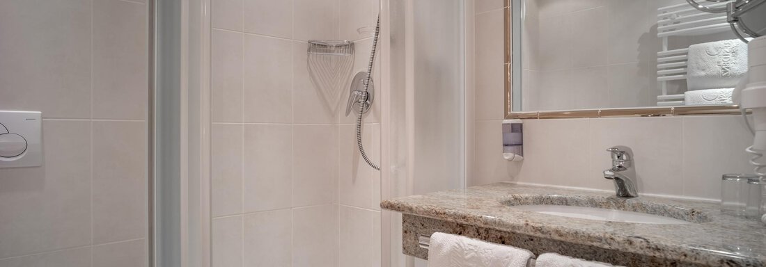A modern bathroom with a clear shower cabin and an elegant granite countertop. Clean towels hang ready, and it is well lit. - Ferienwohnung de Luxe Alpenresidenz am Mühlbach - Obergurgl 