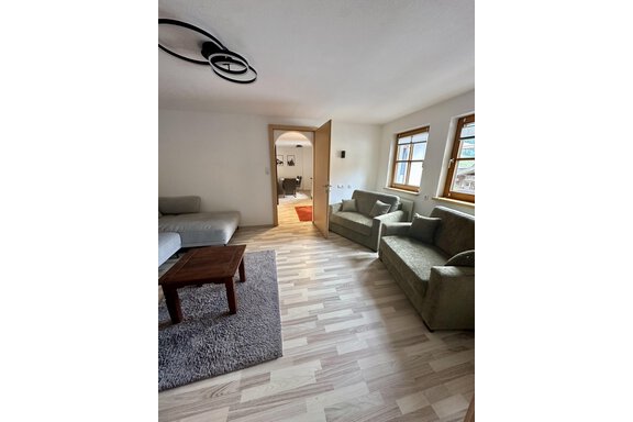 A bright living room with a cozy couch and two armchairs. The wooden table is on a gray carpet. - Forest Chalet - Obergurgl 