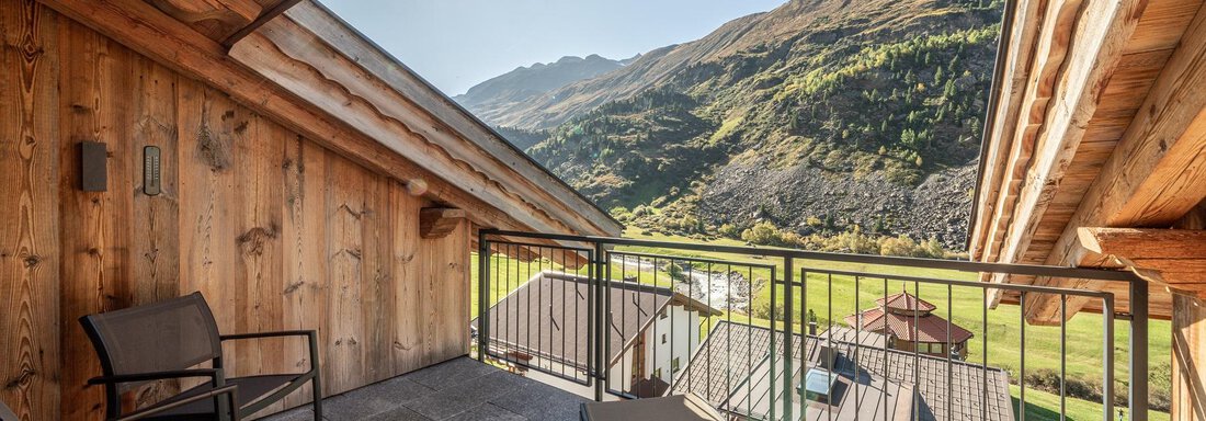 A balcony with a beautiful view of the mountains and the green landscape. The sun is shining and there is a clear sky to be seen. - Gletscherblick - Serviced Apartments - Obergurgl 