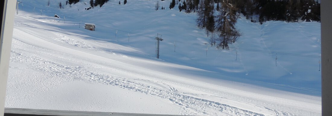 A snow-covered winter landscape with high mountains and a beautiful blue sky. In the foreground, there is a balcony with a railing. - Haus Christophorus - Obergurgl 