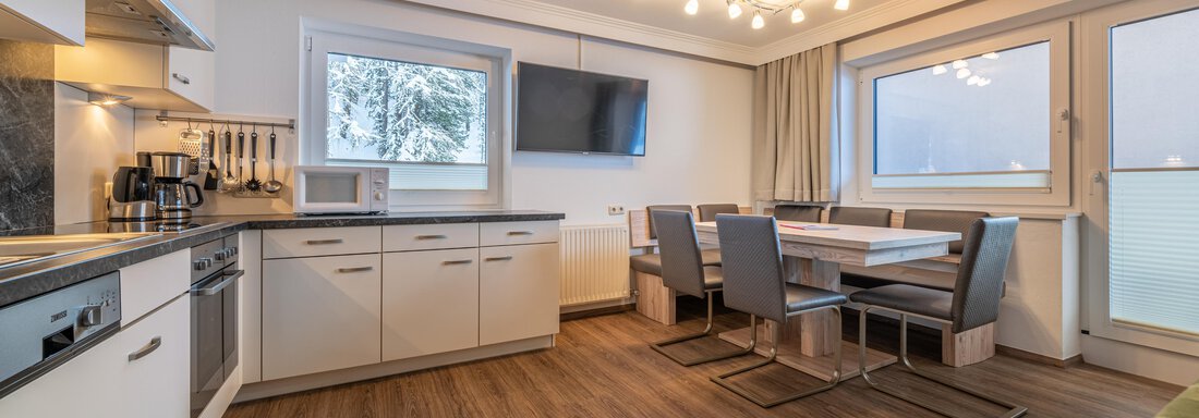Modern kitchen with open living area and dining table. Large windows provide plenty of daylight. - Haus Timmelseck - Obergurgl 