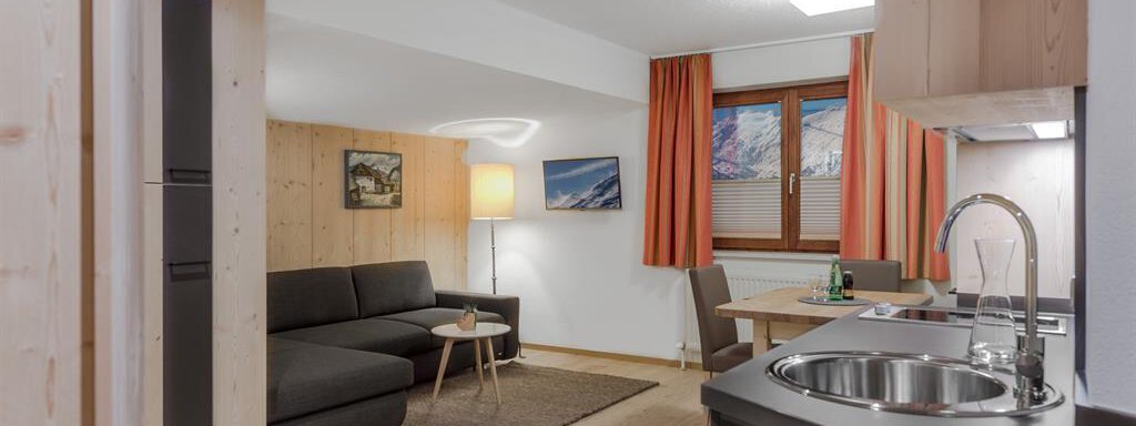 A cozy living kitchen with modern furniture and wood paneling. The room has large windows and is bright and inviting. - Hotel-Garni Pirchhütt - Obergurgl 