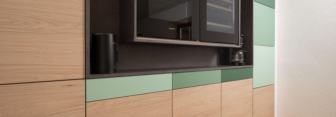 Modern kitchen with wooden fronts and green accents. A built-in microwave oven is visible. - Mountain Lodge Obergurgl - Obergurgl 