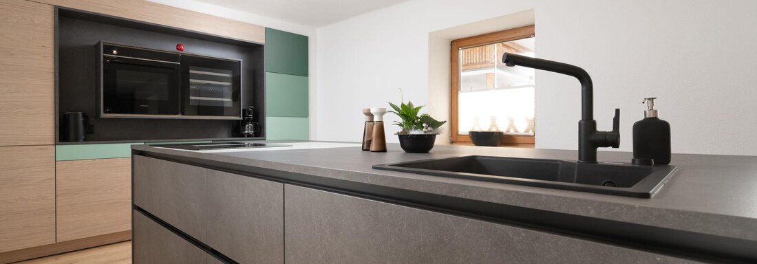 A modern kitchen with an elegant kitchen island and a minimalist design. Bright colors and natural materials create an inviting atmosphere. - Mountain Lodge Obergurgl - Obergurgl 