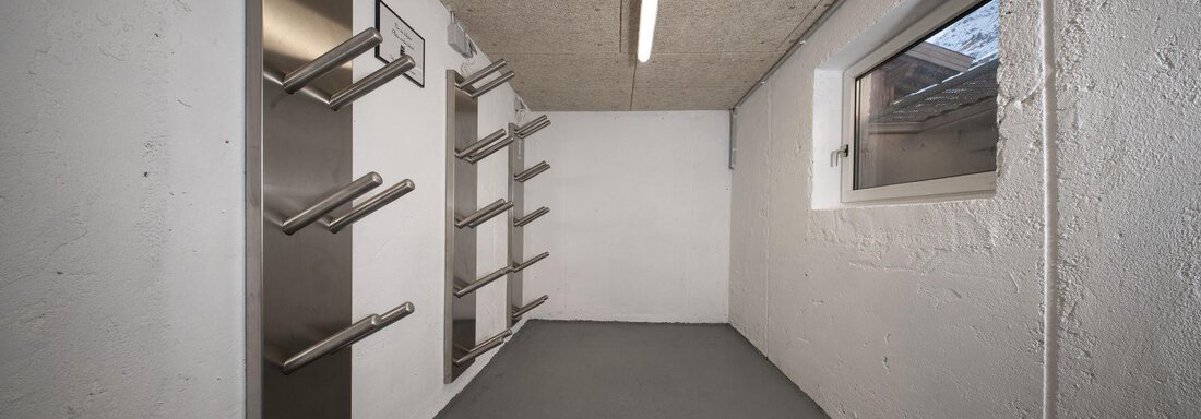 An empty room with a gray floor and white walls. There are stainless steel shelves on the left wall. - Mountain Lodge Obergurgl - Obergurgl 