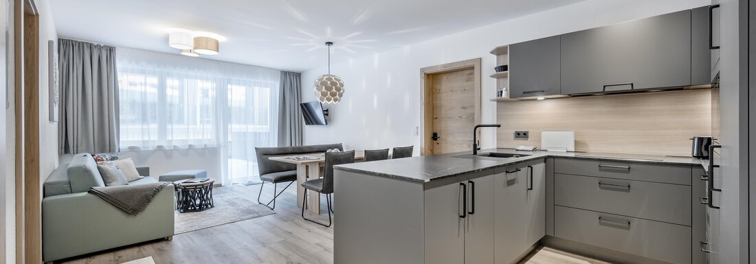 Peak Gurgl - TOP 1 | © Peak Gurgl (CC C) A modern kitchen with an open living area and minimalist decor. The space is bright and inviting, with large windows and modern furniture. - Peak Gurgl - Obergurgl
