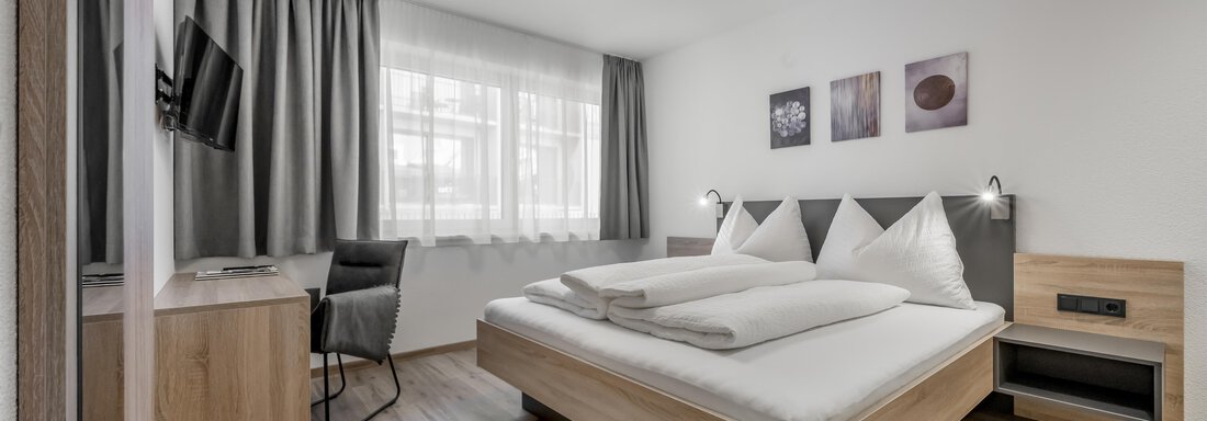 A modern bedroom with a double bed and light wood. Large windows provide plenty of daylight, and the room is stylishly furnished. - Peak Gurgl - Obergurgl 