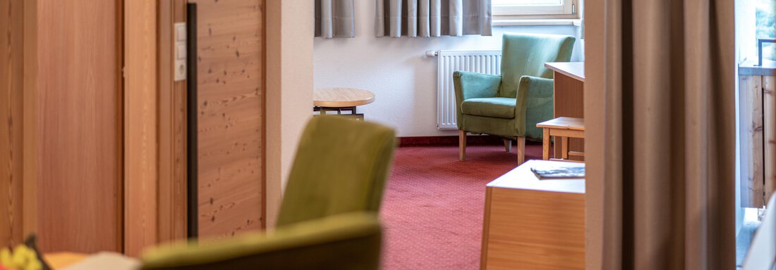A cozy room with green chairs and wooden furniture. The room has a warm carpet and plenty of natural light. - Schönblick Gurgl - Obergurgl 