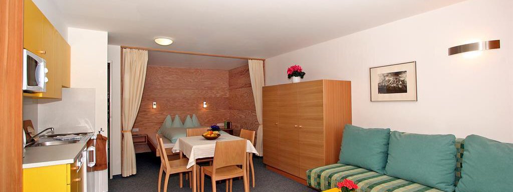 Wohnraum A living room with a modern kitchen corner and a dining table.
Comfortable sofas and a cozy atmosphere create an inviting living space. - Ferienwohnungen Broser - Obergurgl