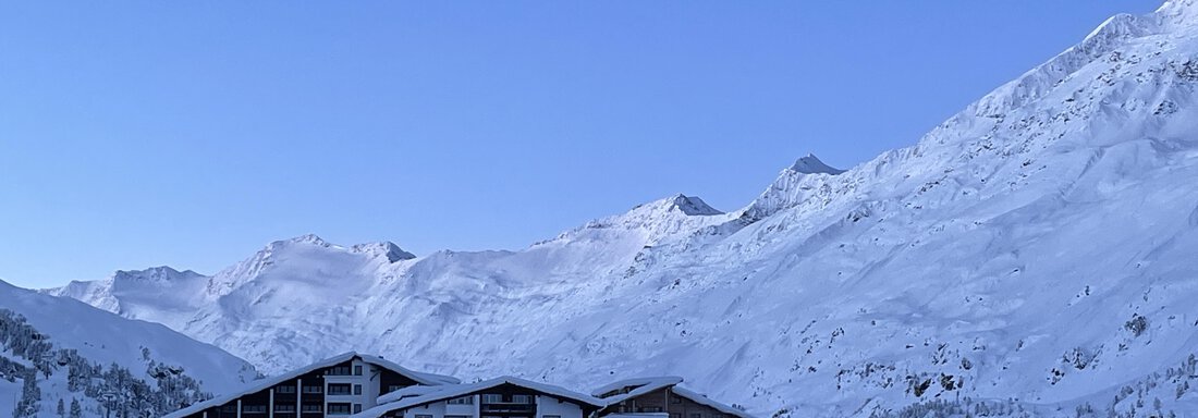 A snow-covered mountain village under a clear blue sky. The surrounding mountains are impressive and steep. - Haus Verwall Appartements - Obergurgl 