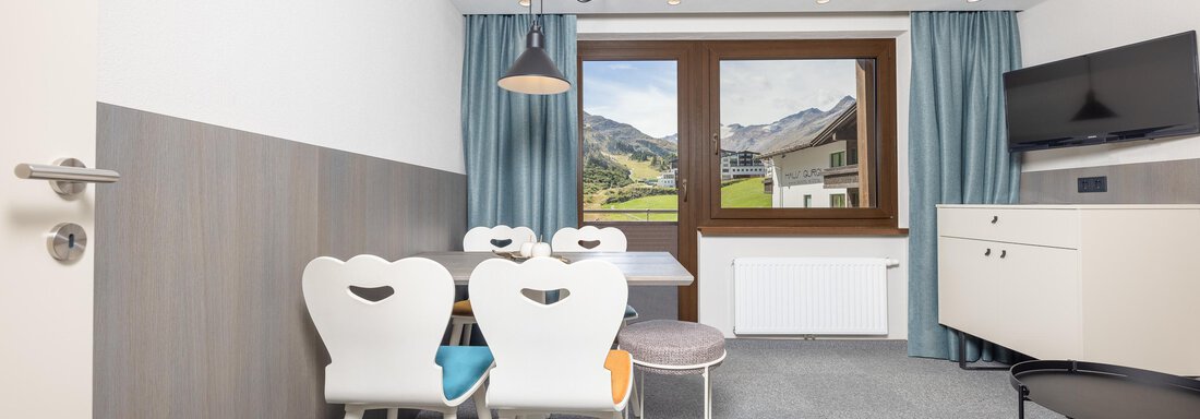 A modern, bright living room with a dining area and a window that offers a view of the mountains. The furniture is stylish and invites you to linger. - Haus Verwall Appartements - Obergurgl 