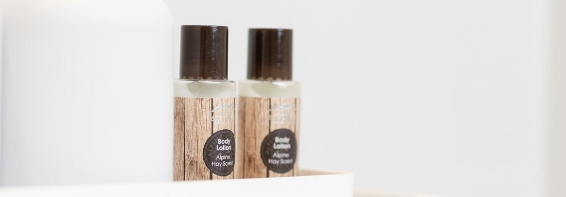 Two small bottles with a natural appearance are on a white tray. They look modern and minimalist. - Haus Verwall Appartements - Obergurgl 