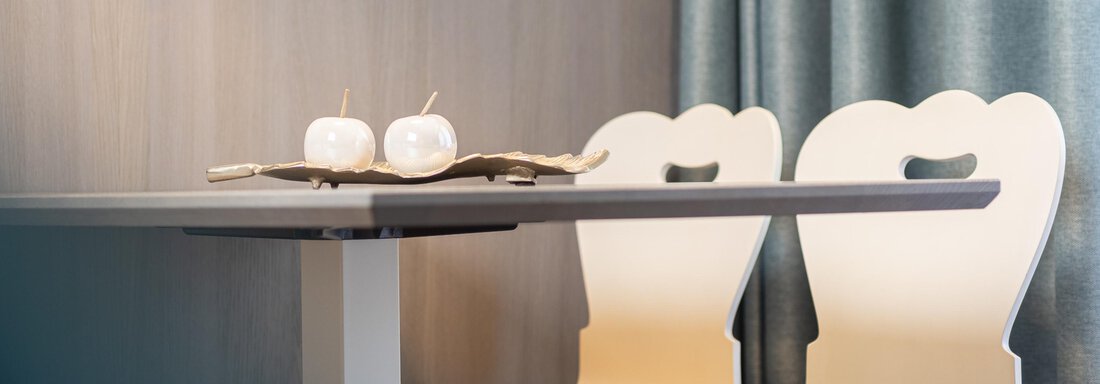 A modern table with two stylish chairs and decorative candles. The room has a cozy atmosphere with soft colors. - Haus Verwall Appartements - Obergurgl 