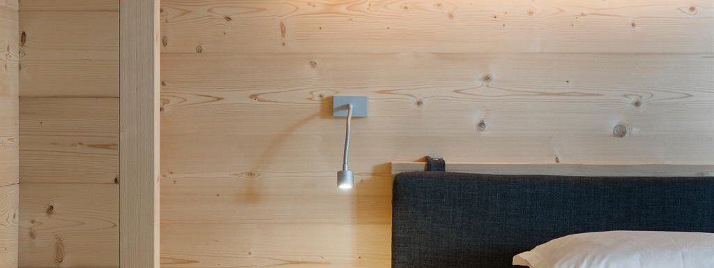 An elegant bedroom with light wood and a modern bed. The soft lighting creates a cozy atmosphere. - Hotel-Garni Pirchhütt - Obergurgl 
