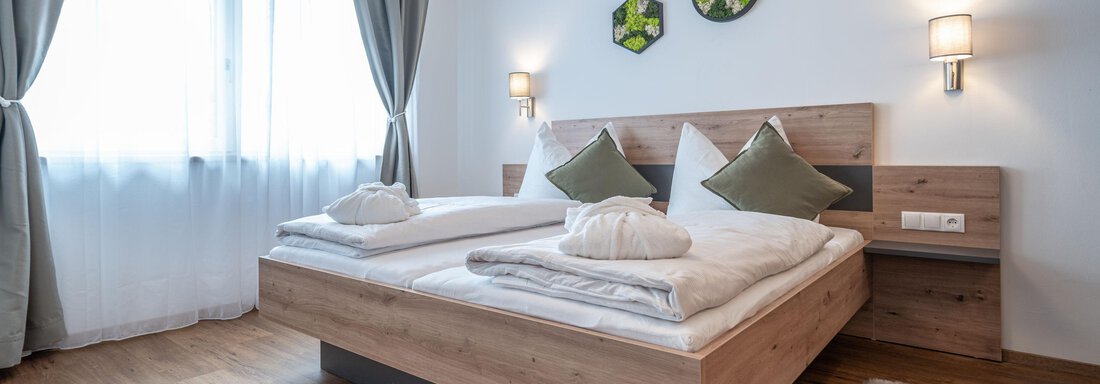 A stylish bedroom with a double bed and modern decorations. Large windows provide plenty of daylight and an inviting atmosphere. - Mein Gaisberg - Obergurgl 