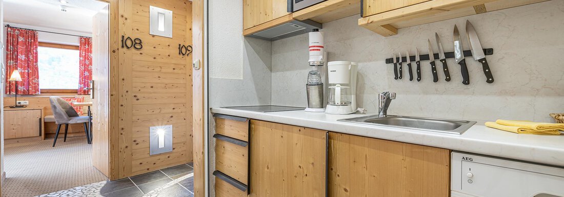 A modern kitchen with wooden cabinets and a simple design. Kitchen utensils and appliances are clearly visible on the countertop. - Schönblick Gurgl - Obergurgl 