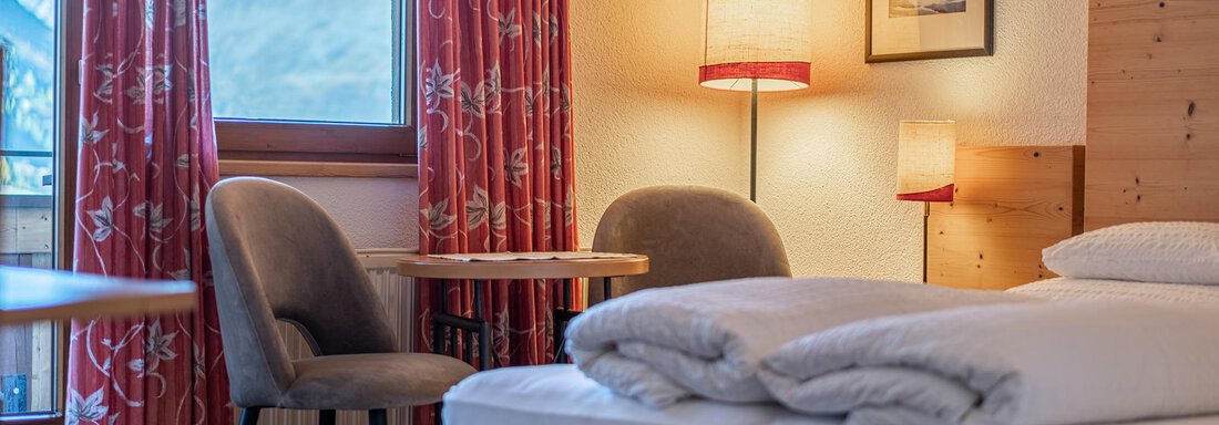 Cozy bedroom with a double bed and two pillows. The room is bright and cheerful with a table, chairs, and a beautiful view of the mountains. - Schönblick Gurgl - Obergurgl 