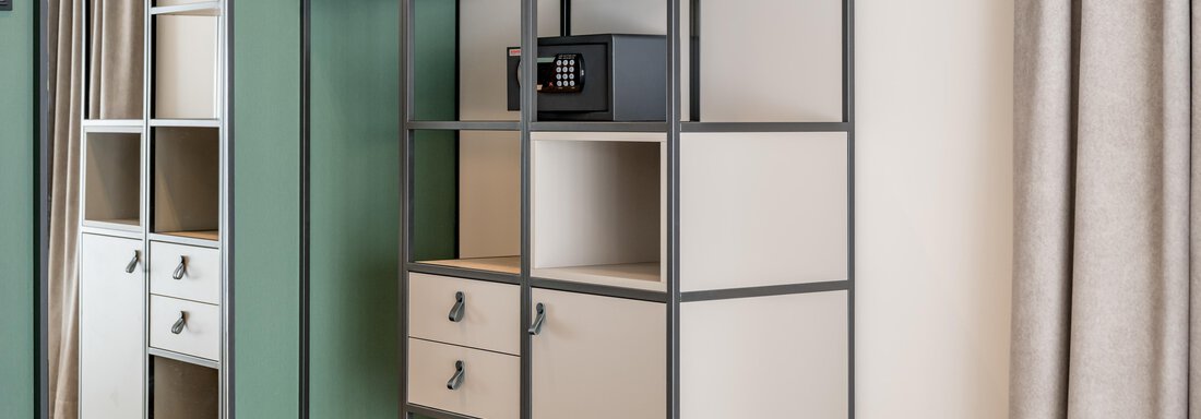 A modern wardrobe with open shelves and a mirror door. The wardrobe includes a drawer, a safe, and a clothes hook. - The Moss - Your unique hideaway - Obergurgl 