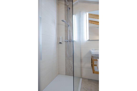 Eine moderne Dusche mit Glasabtrennung und hellem Fliesenboden. Der Raum wirkt sauber und einladend. - Gasthof Waldesruh - Ochsengarten