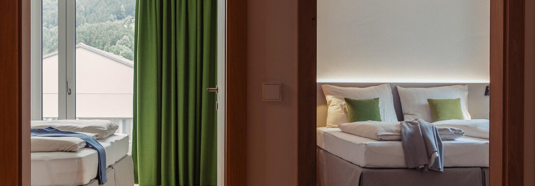 Two cozy bedrooms with modern furniture and inviting colors. Each room offers a calm atmosphere and natural lighting. - All-Suite Resort Ötztal - Oetz