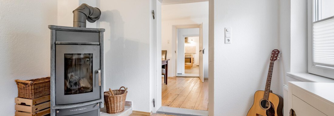 Kaminofen mit Durchgang zu Zwischenraum und Küche - Haus Alpenblick - Oetz