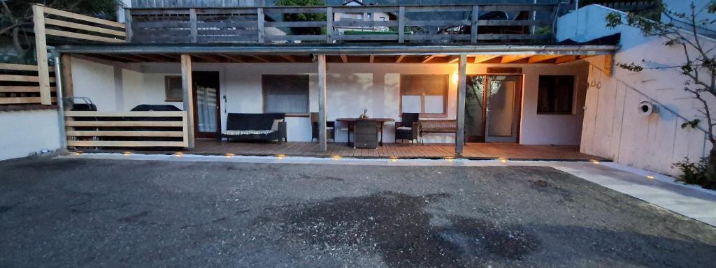 A cozy outdoor area with seating and a table, surrounded by a tranquil landscape. In the background, mountains can be seen, and it is already evening. - Appartement Harmony - Sautens