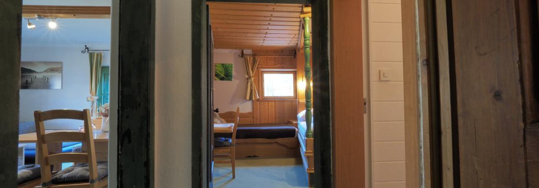 Ein gemütlicher Innenraum mit mehreren Türen. Man sieht einen holzvertäfelten Raum und Stühle im Hintergrund. - bei Herrmann´s - Sautens