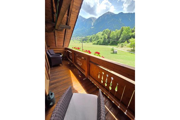 A beautiful balcony with a view of the mountains and a green landscape. Geraniums are blooming in the flower boxes and the sun is shining. - Ferienhof Strigl - Sautens