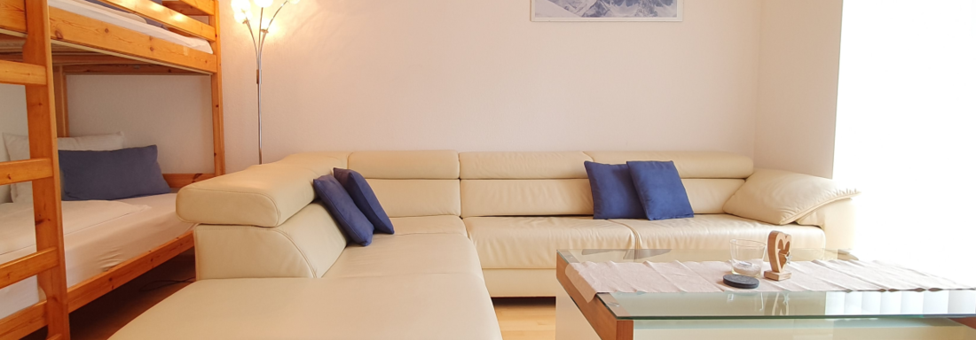 Bright living room with large couch - Ferienwohnung "Zum Glück" - Sautens