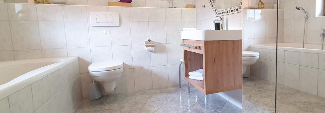 first bathroom with bathtub, WC, washbasin - Ferienwohnung "Zum Glück" - Sautens
