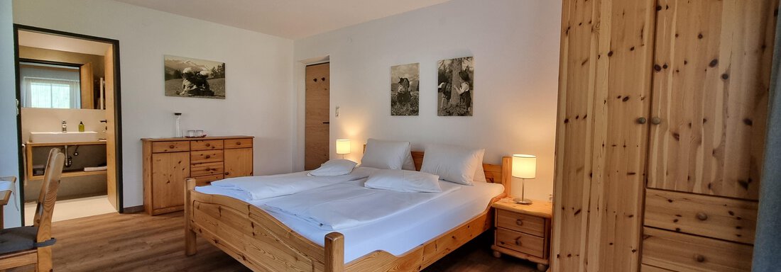 Geräumiges Zimmer mit einem Doppelbett und Sofa - Haus Alpenglühn - Sautens