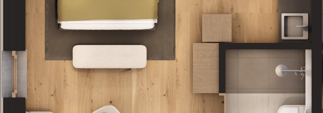 A modern hotel room with a large bed, a comfortable armchair, and a table. The room has a bright wooden floor and an attached small bathroom section. - A CASA "Aventurin" - Sölden