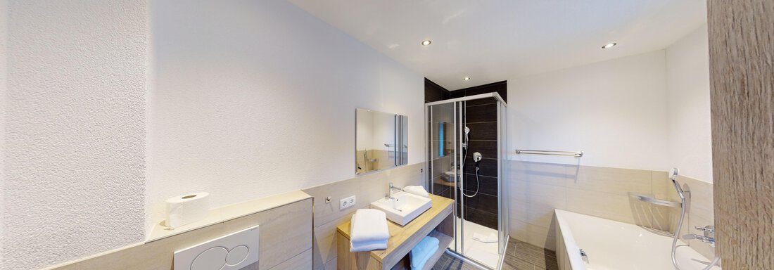 A modern bathroom with a shower, bathtub, and a wooden vanity. Bright walls and stylish tiles create an elegant atmosphere. - A CASA "Rubin Chalet & Studio Resort" - Sölden