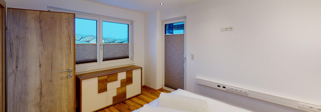 A modern bedroom with two beds and two towels.  
Large windows provide plenty of daylight and a friendly atmosphere. - A CASA "Rubin Chalet & Studio Resort" - Sölden