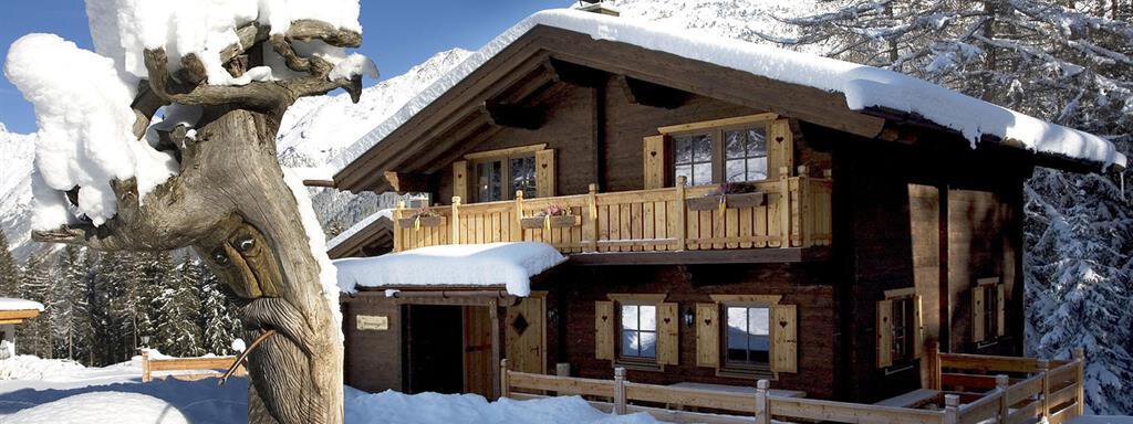 A beautiful chalet in the snow, surrounded by a winter landscape. The snow-covered surroundings and the mountains in the background create a picturesque atmosphere. - Almdorf Waldesruh - Sölden
