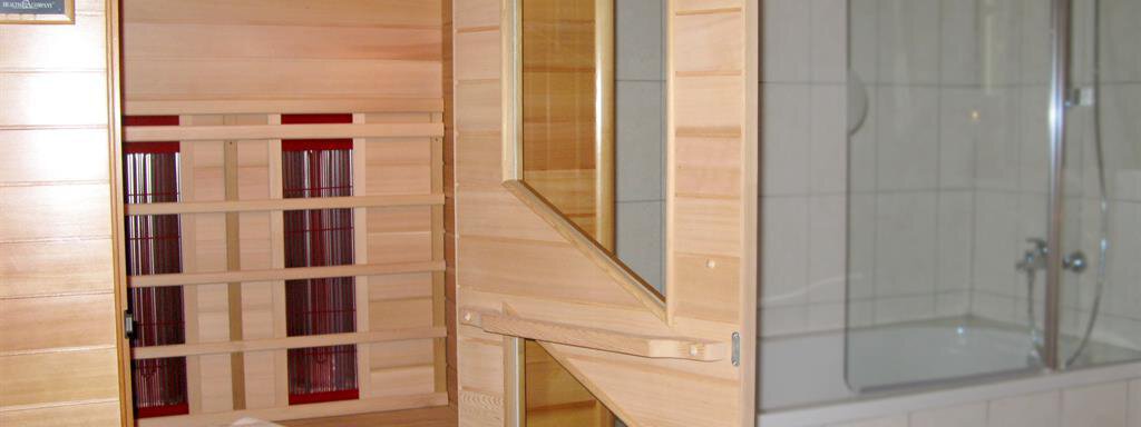 A modern sauna with wooden paneling and a shower area. The atmosphere is relaxing and inviting. - Almdorf Waldesruh - Sölden